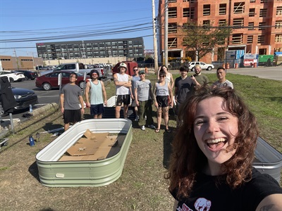 A group of young people from the Nak Muay Naturalists take a selfie with their constructed raised beds.