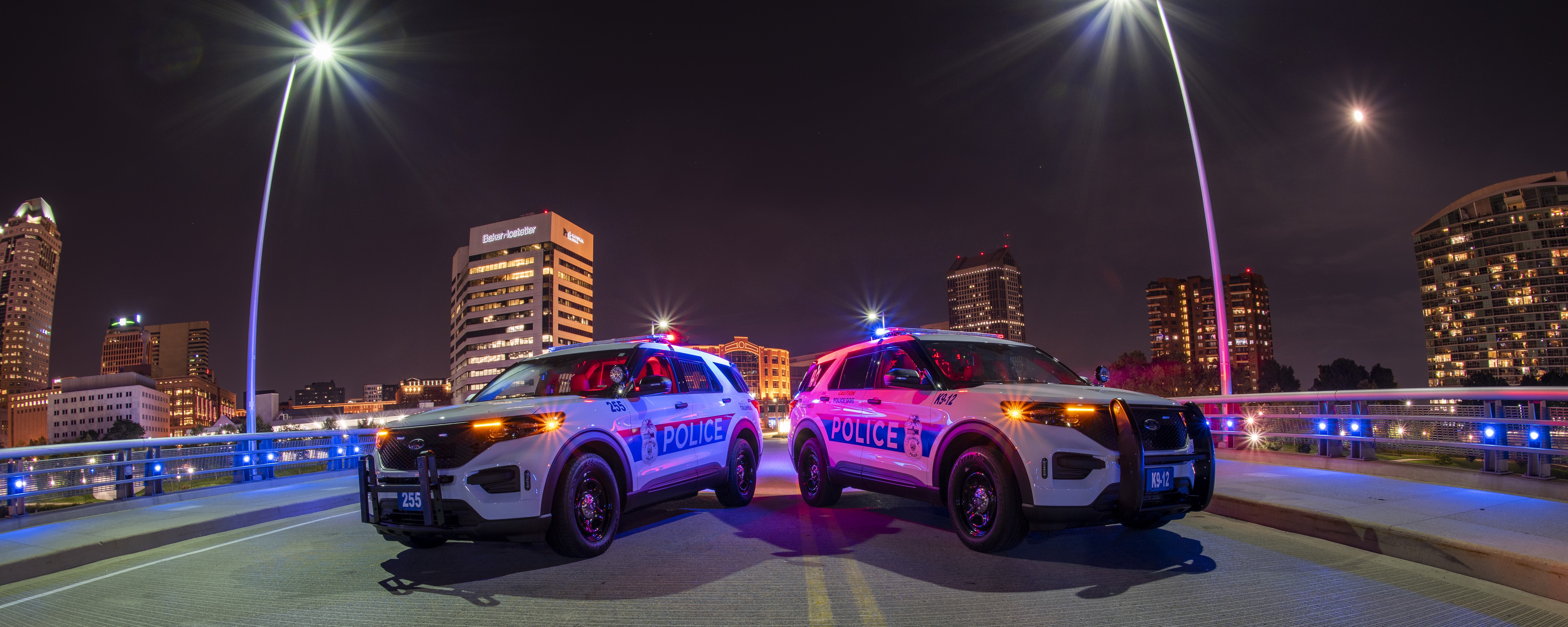 Two Police Cruisers blocking a road at night