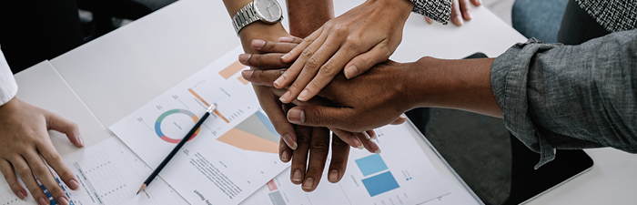 Diverse hands together above office table